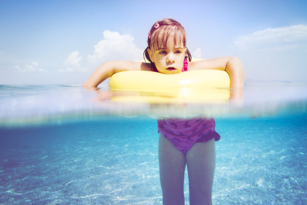 懒惰的小女孩在游泳管里漂浮在海上图片下载