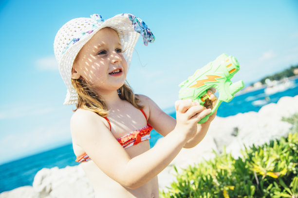 戴着夏帽玩水枪的小女孩图片下载