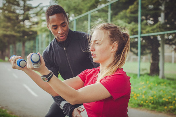 男人帮助女人正确地用哑铃做运动图片下载
