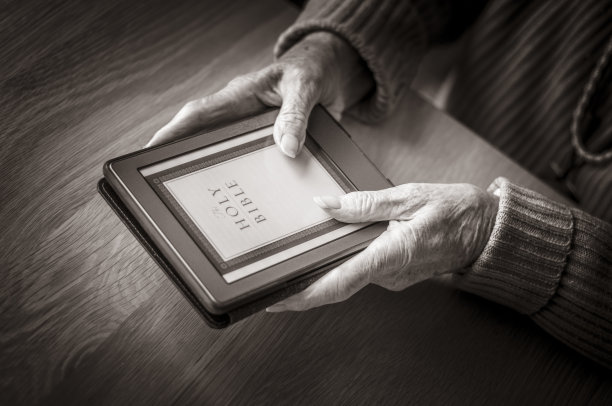 老妇人拿着电子阅读器看圣经图片下载