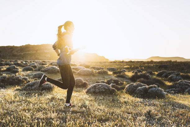 一个年轻女子在一个阳光明媚的日子慢跑图片下载
