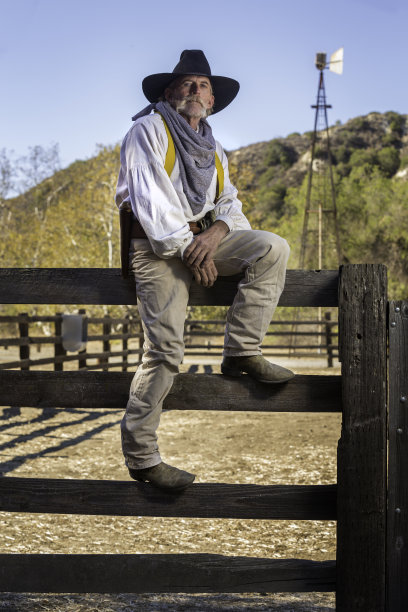 牛仔坐在篱笆上图片下载