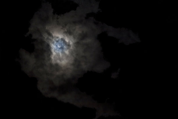 满月和怪异的白云映衬着黑色的天空图片下载