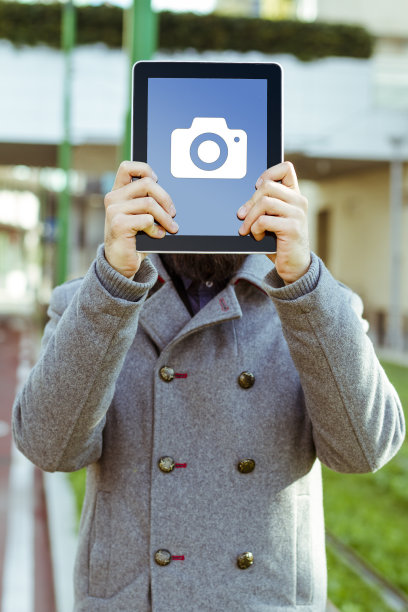 一名男子将平板电脑举在面前图片下载