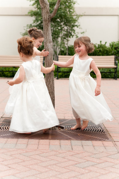 三个快乐的花童穿着礼服一起玩图片下载