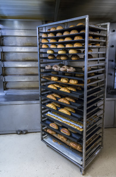 新鲜的法国面包在面包房的冷却架上图片下载