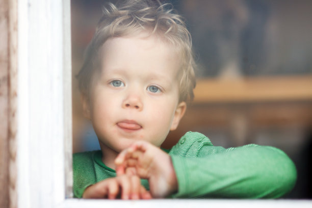 小男孩从窗户往里看图片下载