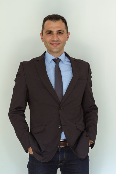 一个穿着入时的年轻人站在墙边图片下载