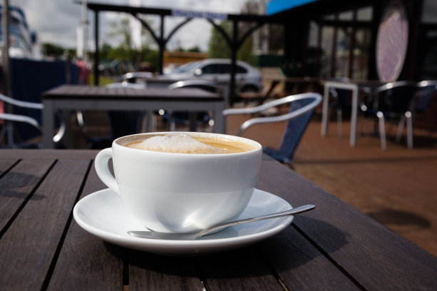 英国诺福克户外咖啡馆野餐桌上的拿铁咖啡杯图片下载