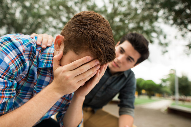 年轻人用手捂着脸，旁边的朋友图片下载