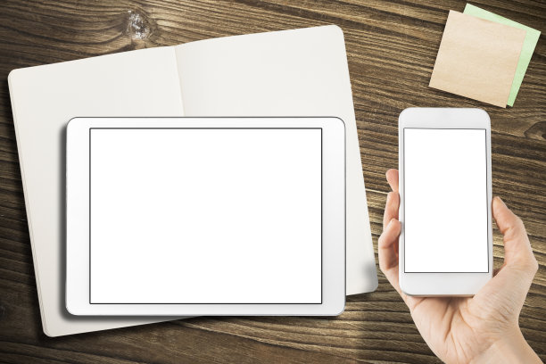 数字平板电脑与便利贴和笔记本在旧木头上。图片下载