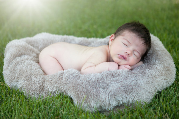 新生婴儿睡在草皮毯子上图片下载