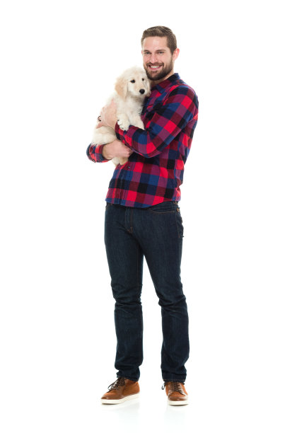 微笑的男人拥抱着他的小狗图片下载