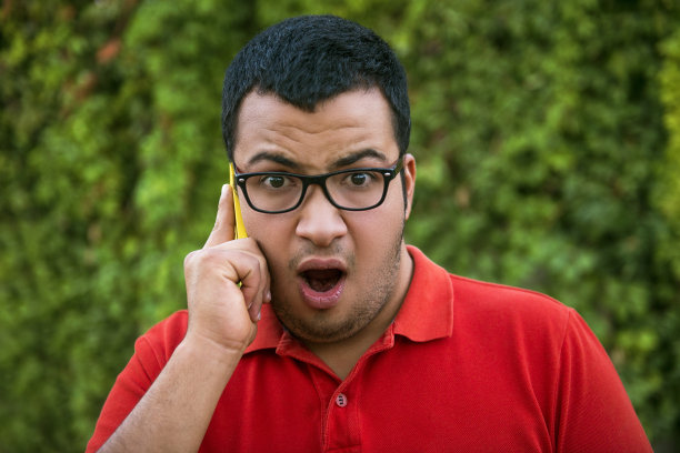 震惊的年轻人打电话的肖像图片下载