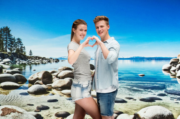 一对幸福的夫妇在海滩上做一个心形图片下载