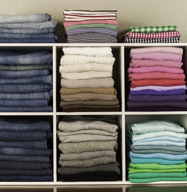 妇女的衣服整齐地摆放在白色的小隔间里图片下载