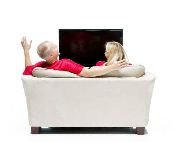 后视图微笑的夫妇坐在沙发上图片下载