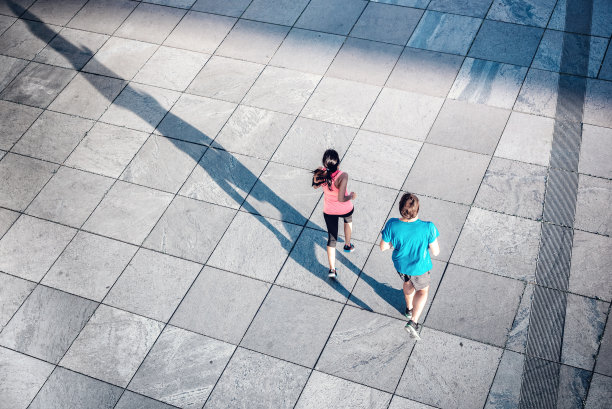 女人和男人一起在几何瓷砖广场上慢跑图片下载