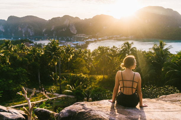 一个女人在夕阳下看着皮皮岛的景色素材图片