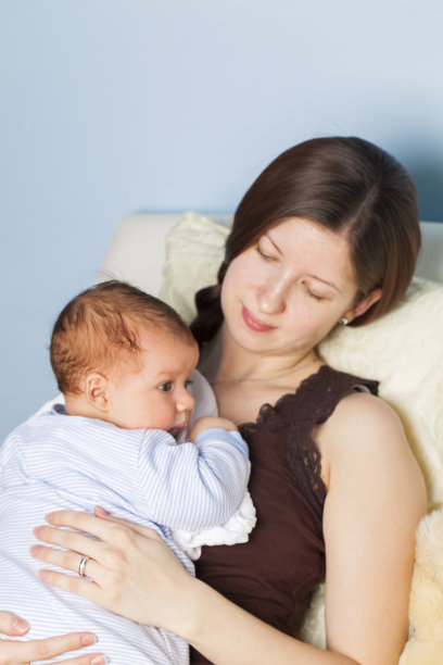 年轻的母亲和小男孩依偎在她的胸前图片下载