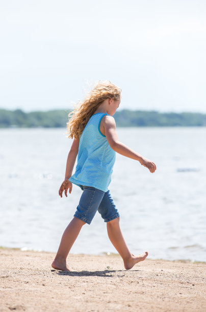 赤脚女孩在沙滩上漫步图片下载