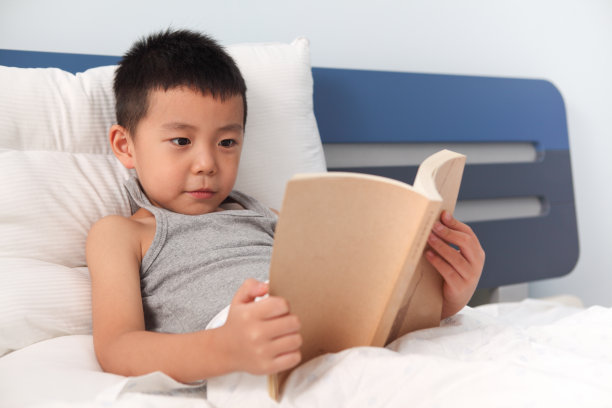 亚洲男孩在床上看书图片下载