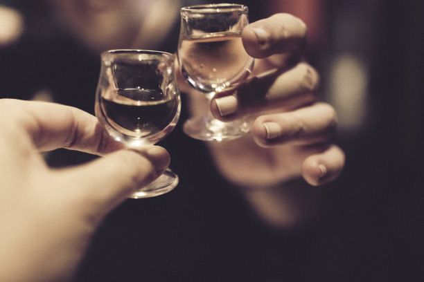 一对夫妇在饭后庆祝和欢呼好消息，每人手里都拿着杏仁利口酒。图片下载