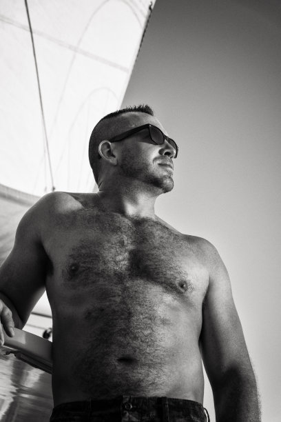 日落时分站在帆船上的成年男子图片下载