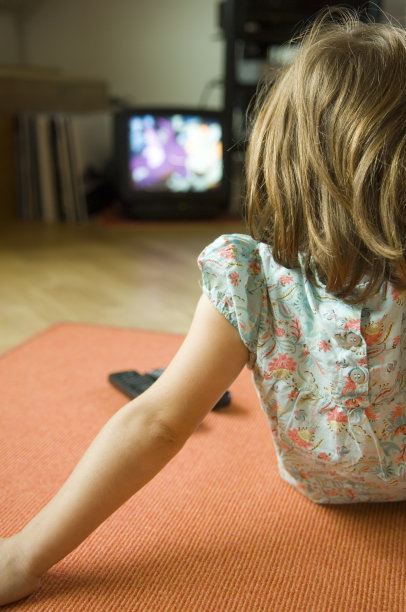 看电视的可爱小女孩。图片下载