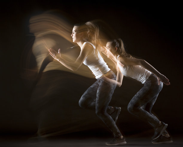 女运动员在黑色背景上练习动作模式图片下载