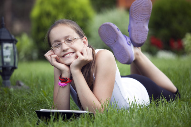 美丽的少女微笑和享受在自然与桌子图片下载