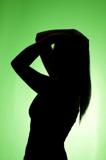 美丽的女士侧姿势剪影绿色背景-库存图像图片下载