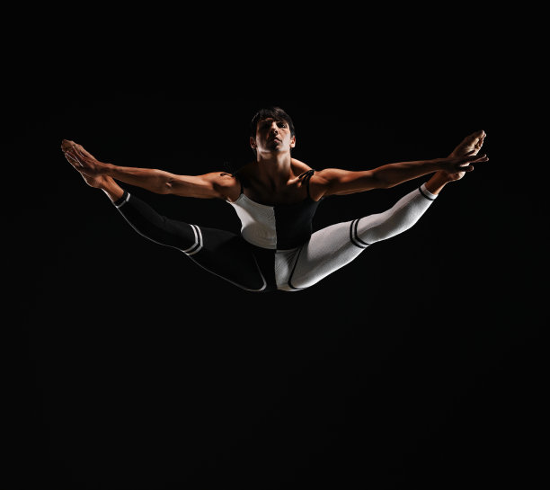 男芭蕾舞演员在半空中劈叉，脚尖向外图片下载