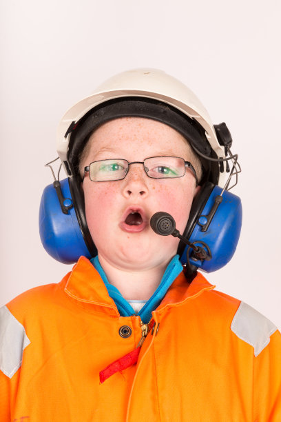 男孩穿着石油工业防护服使用无线电图片下载