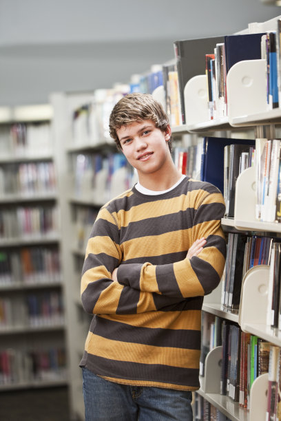 一个少年站在图书馆里素材图片