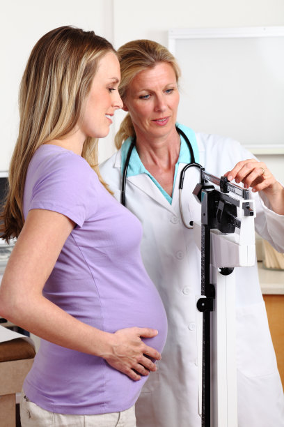 护士在磅秤上测量孕妇的体重图片下载