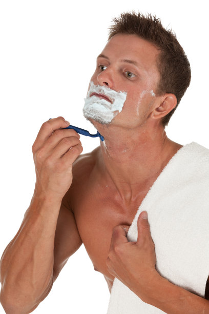 英俊的年轻人用剃须刀刮胡子图片下载