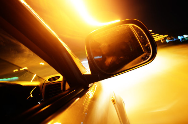 在夜晚超速行驶的汽车，有明亮的橙色灯光图片下载