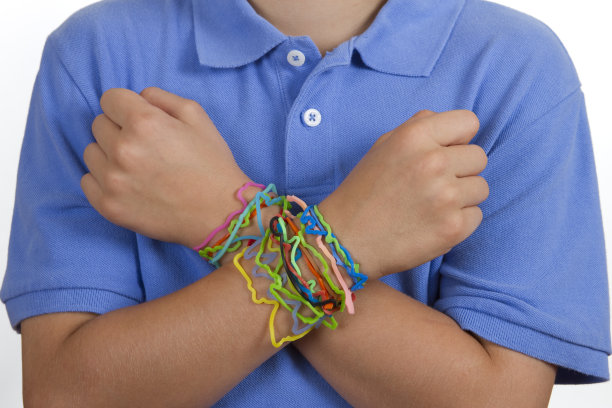 孩子，交叉手臂上的橡皮筋手镯图片下载