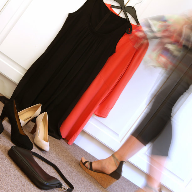 女人从各种各样的衣服和鞋子中选择穿什么图片下载
