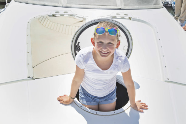 年轻的白人女孩从船头游艇的舱口出来图片下载