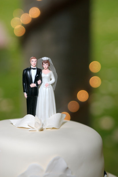 新娘和新郎在婚礼蛋糕上的装饰图片下载