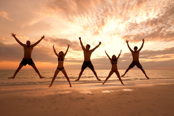 多民族的朋友跳在海滩上玩图片下载