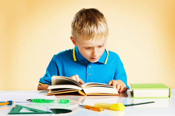 小男孩一心要在课桌上看书图片下载