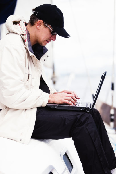 在帆船上带着笔记本电脑的商人图片下载