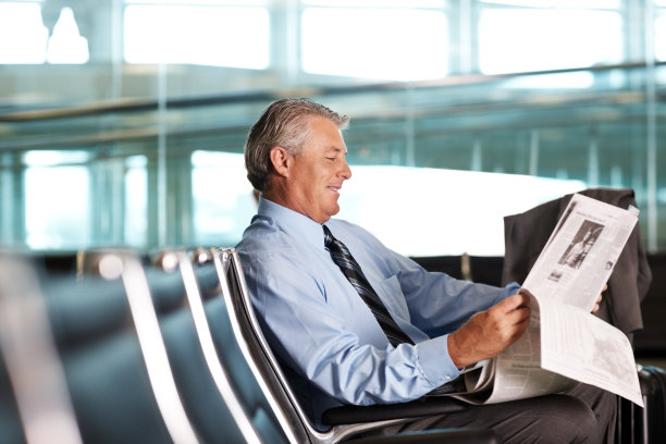 在机场看报纸的成熟商人图片下载