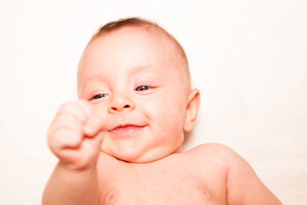 微笑的婴儿在白色的手臂和拳头举起图片下载