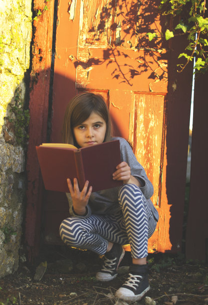 傍晚阳光下拿着书的女孩图片下载