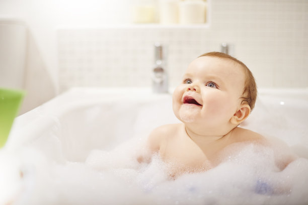 小男孩在他的泡泡浴里笑图片下载