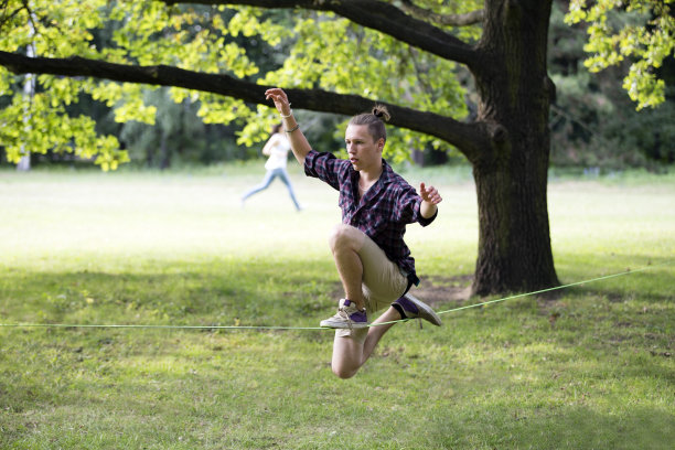 在松弛的绳索上保持平衡的少年图片下载